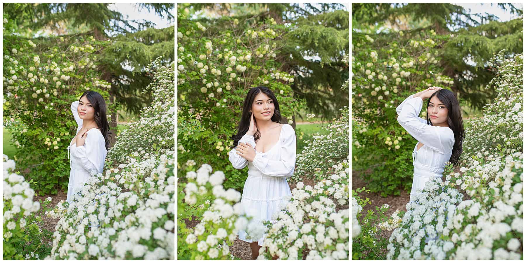 Class of 2025 senior in a white dress surrounded by white flowering bushes for senior portraits in Santa Fe, New Mexico