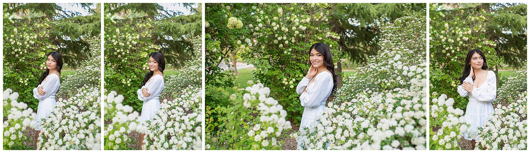 Senior girl smiling in a white dress surrounded by blooming white flowers during her Rio Rancho, NM senior photoshoot.