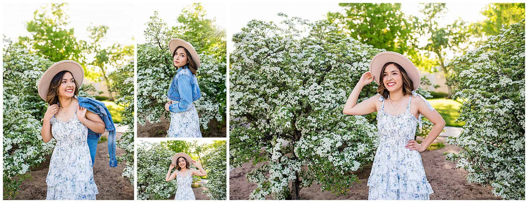 Graduating senior in a flowy white and blue floral dress with cowgirl boots near white flowering bushes in Albuquerque.
